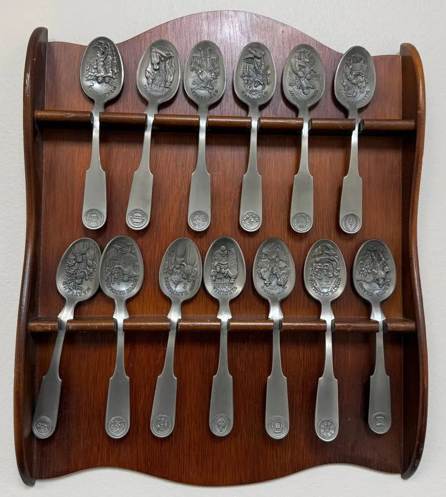 Franklin Mint 13 Original American Colonies pewter spoons with a wooden display rack. Coin Hub
