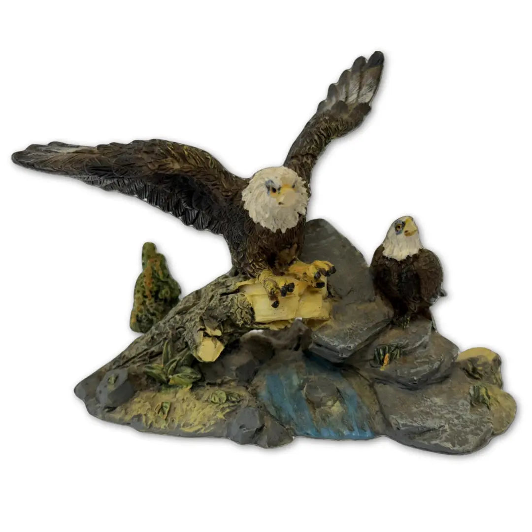Sculpture features two bald eagles perched on a rock and branch formation